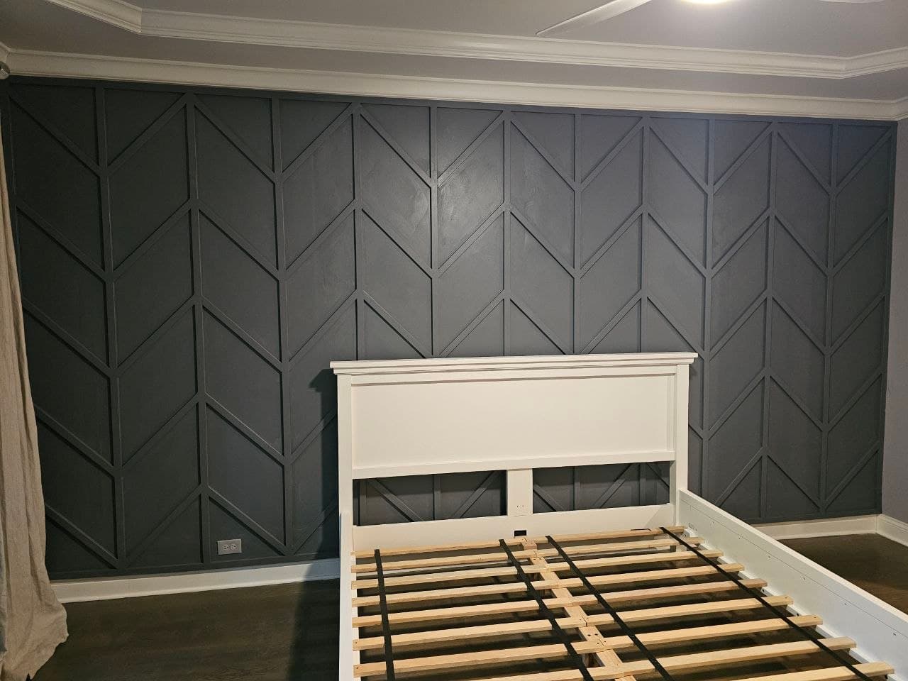 Gray chevron board & batten accent wall behind a bed frame