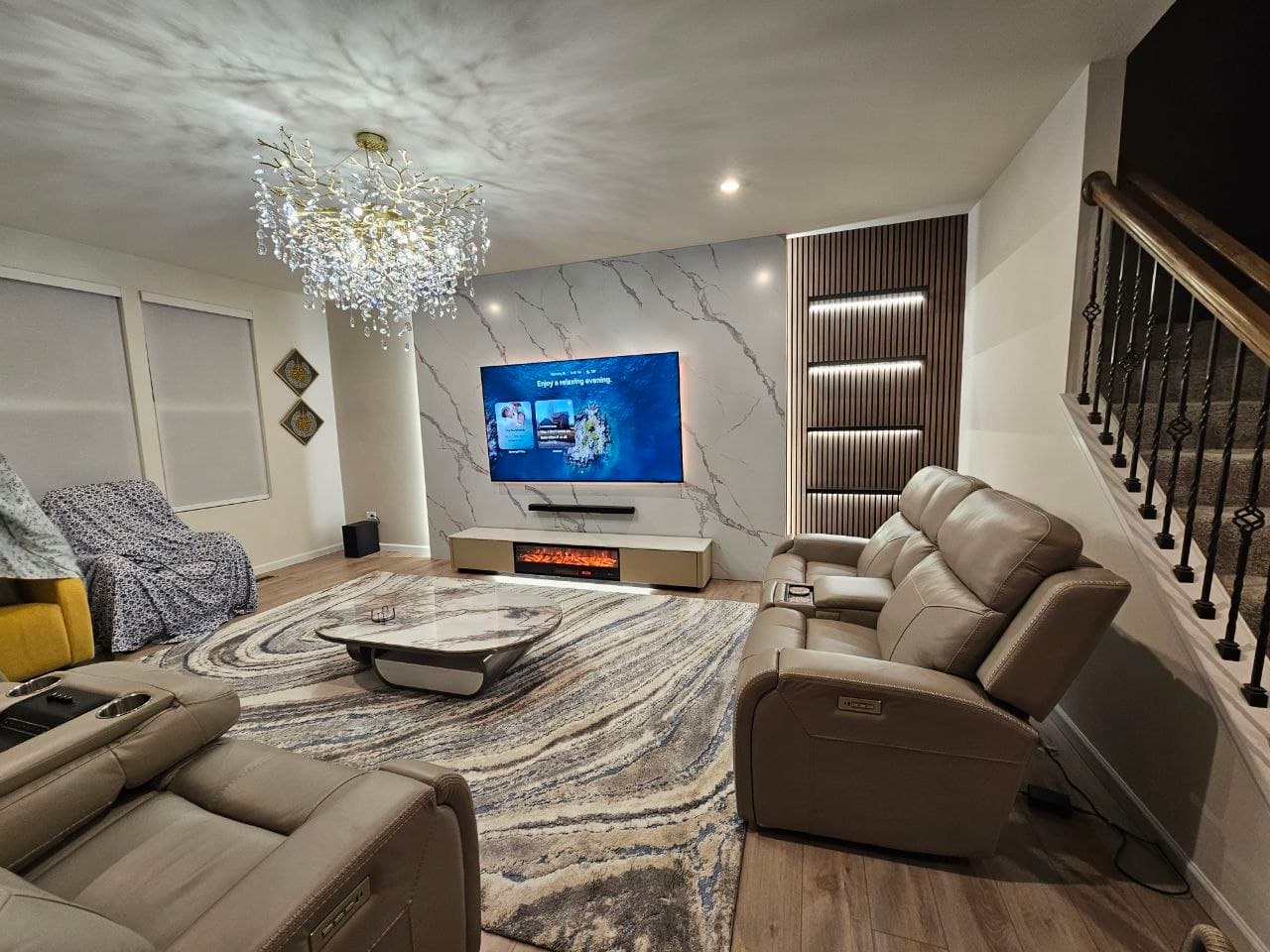 Home theater with marble-look accent wall and a recessed wood slat shelving nook
